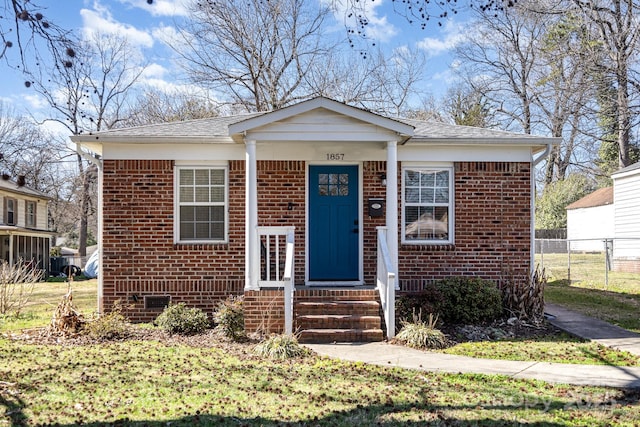 bungalow-style house with entry steps, roof with shingles, crawl space, fence, and brick siding