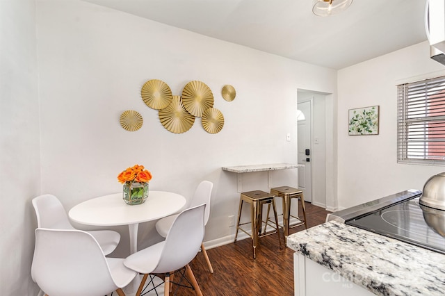 dining area featuring dark wood-style floors and baseboards