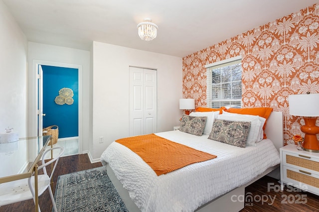 bedroom featuring a closet, baseboards, and wood finished floors