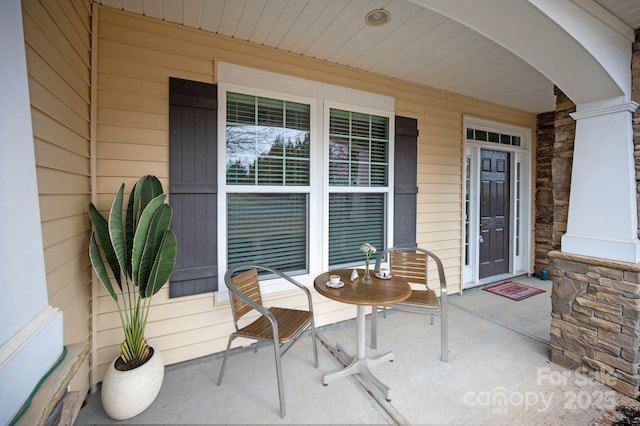 property entrance featuring a porch and stone siding