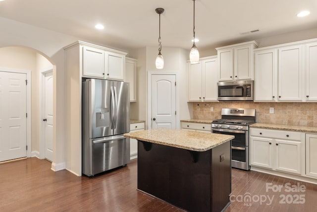 kitchen with appliances with stainless steel finishes, white cabinets, and light stone counters