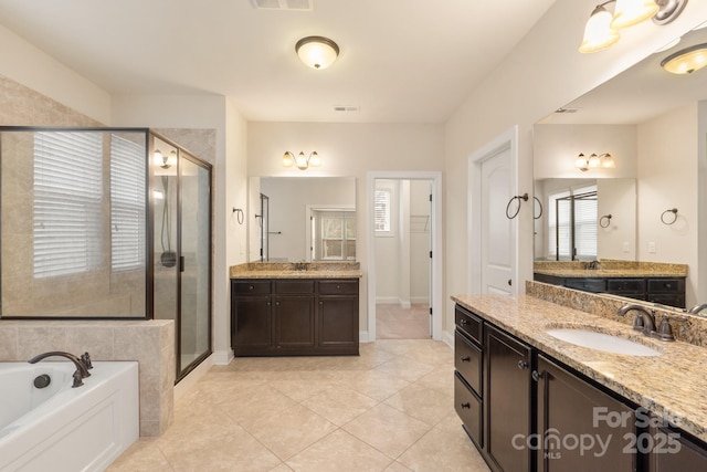 bathroom featuring two vanities, a garden tub, a sink, and a shower stall