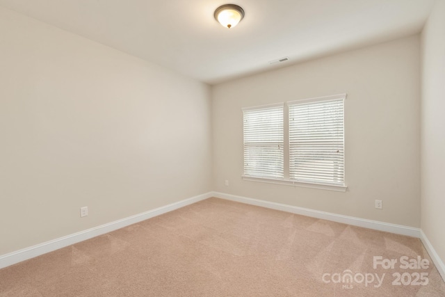 empty room featuring light carpet, baseboards, and visible vents