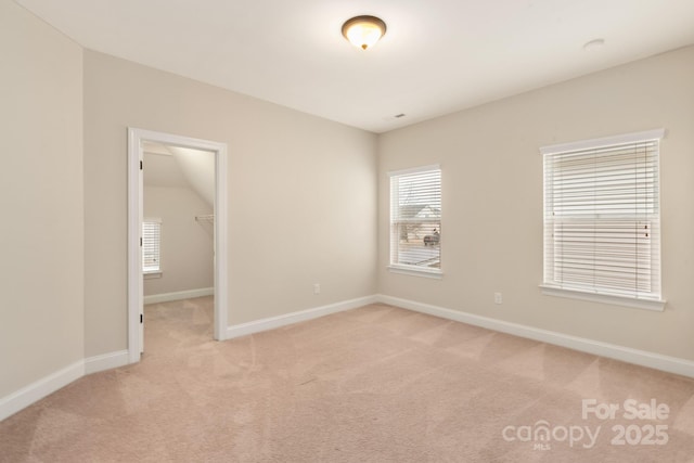 unfurnished room with baseboards and light colored carpet