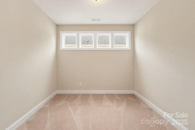 unfurnished room with carpet, visible vents, and baseboards