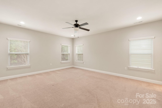 empty room with baseboards, ceiling fan, recessed lighting, and light colored carpet