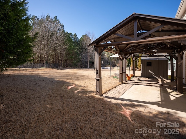 view of yard with a shed, an outdoor structure, and fence