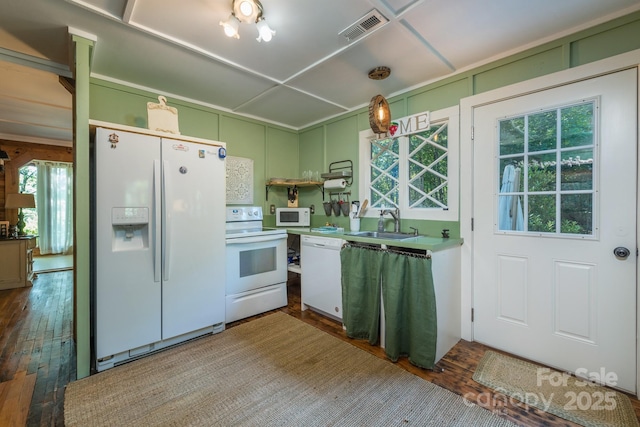 kitchen with white appliances, visible vents, dark wood-style flooring, light countertops, and a sink