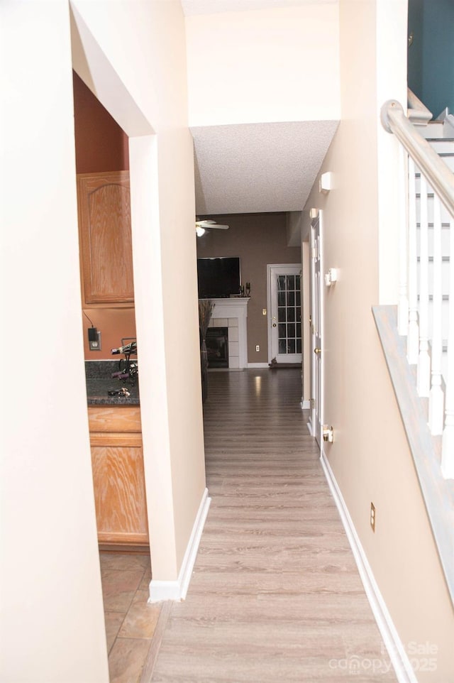 corridor with baseboards and stairs