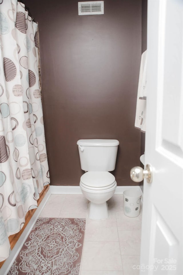 bathroom featuring toilet, tile patterned flooring, visible vents, and baseboards