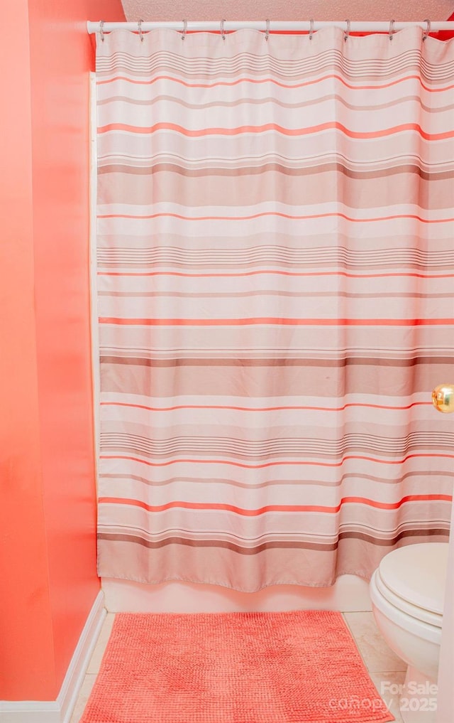 bathroom featuring a textured ceiling, toilet, and tile patterned floors