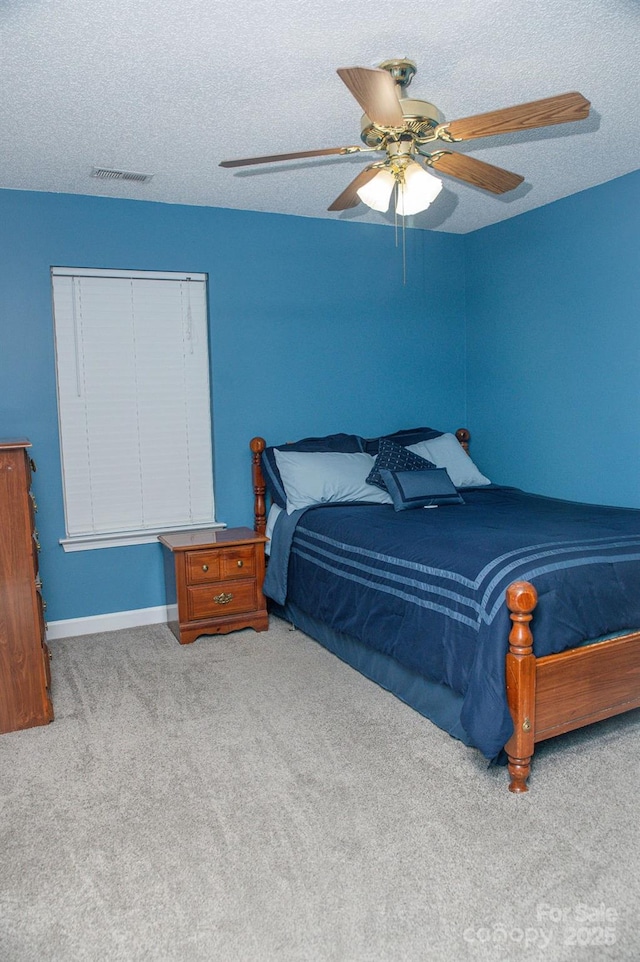 bedroom featuring a textured ceiling, visible vents, a ceiling fan, and light colored carpet