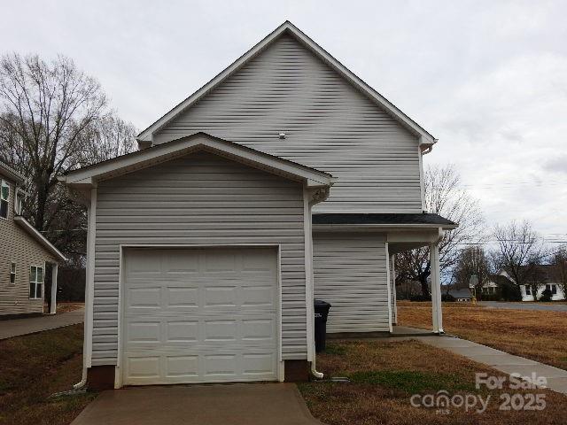 view of side of property with a garage and concrete driveway