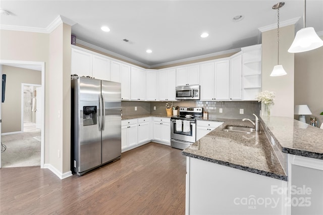 kitchen featuring stainless steel appliances, a peninsula, a sink, open shelves, and decorative light fixtures