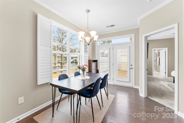 dining area featuring ornamental molding, dark wood-type flooring, baseboards, and an inviting chandelier