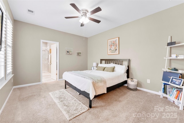 carpeted bedroom featuring ensuite bath, baseboards, visible vents, and ceiling fan