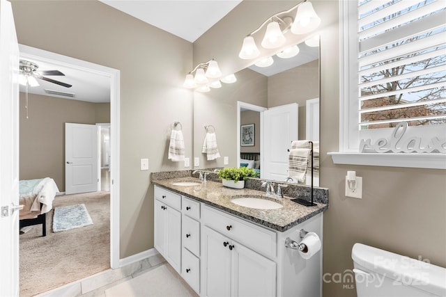 bathroom featuring double vanity, a sink, toilet, and a ceiling fan