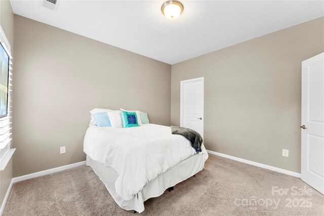 bedroom featuring visible vents, baseboards, and light colored carpet