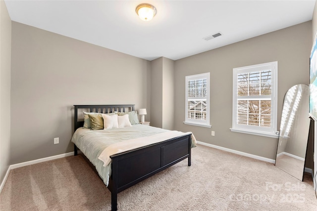 carpeted bedroom with visible vents and baseboards