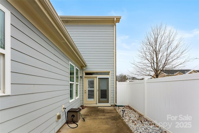 view of side of home with a fenced backyard and a patio