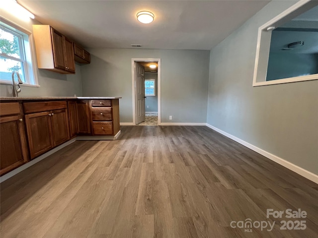 interior space with light wood-type flooring, visible vents, and baseboards