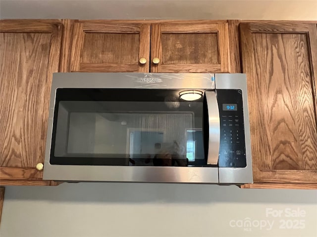 details with brown cabinetry and stainless steel microwave