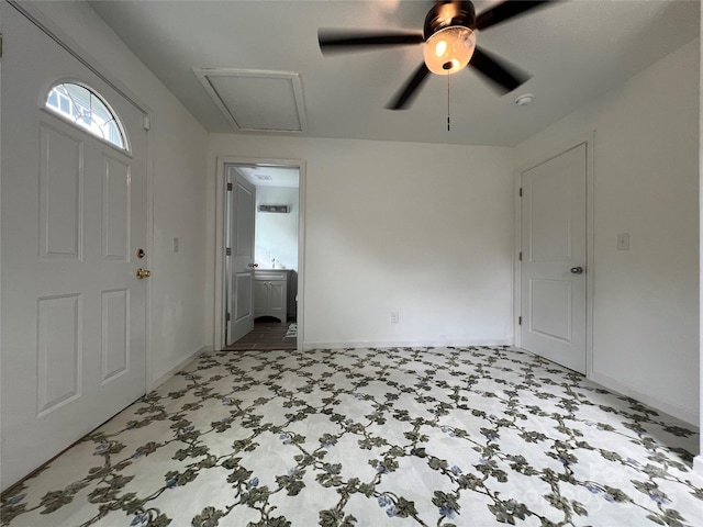 foyer featuring light floors, a ceiling fan, and baseboards