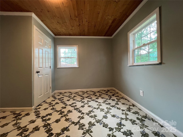 spare room with carpet, wood ceiling, baseboards, and crown molding