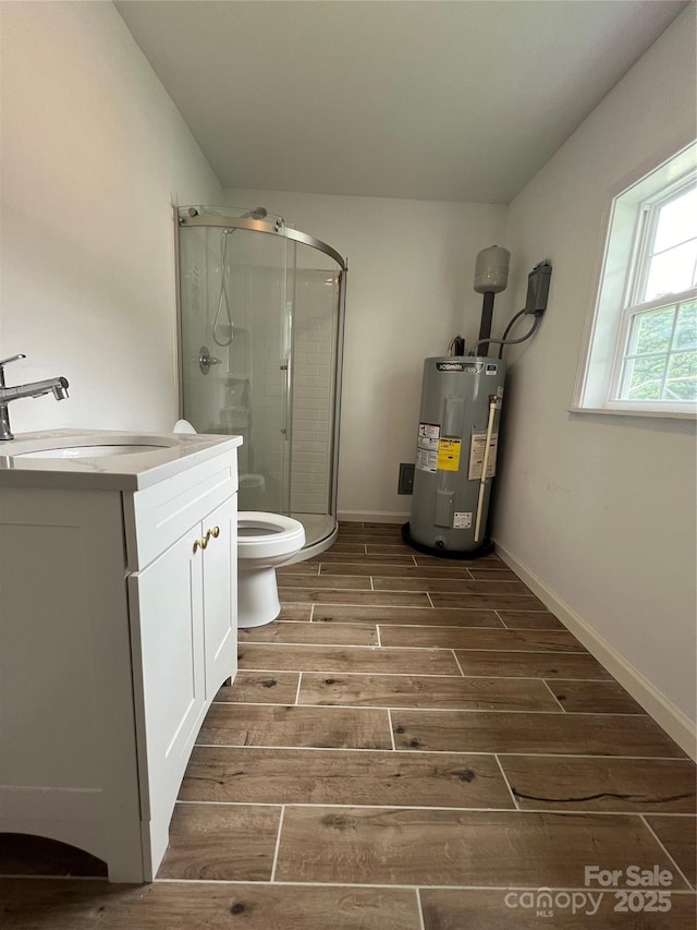 bathroom with toilet, electric water heater, vanity, a shower stall, and wood finish floors