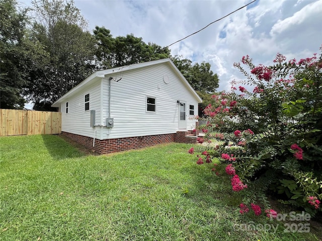 view of side of home featuring a yard and fence