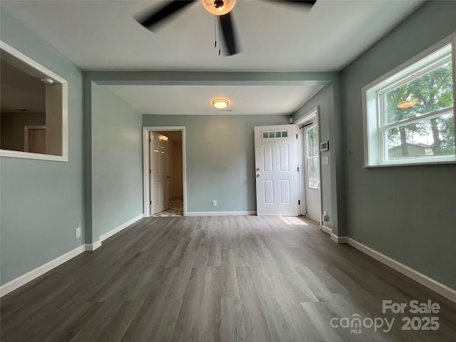 interior space featuring baseboards and wood finished floors