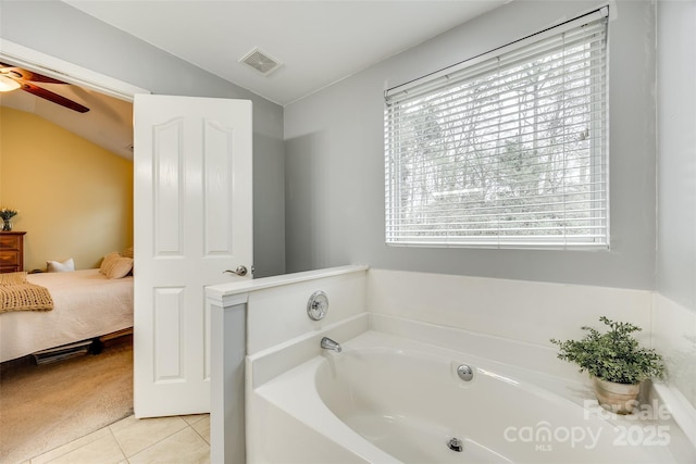 bathroom with lofted ceiling, a garden tub, plenty of natural light, and visible vents