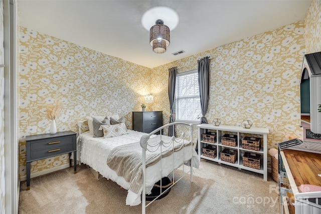 bedroom featuring carpet flooring, visible vents, and wallpapered walls