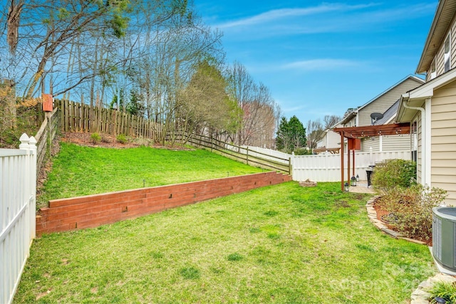 view of yard with a fenced backyard and central AC unit