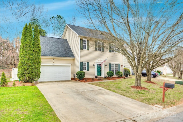 colonial home with a garage, concrete driveway, a front lawn, and roof with shingles