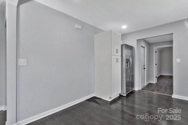 empty room with dark wood finished floors and baseboards