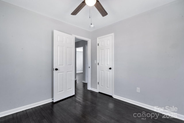 unfurnished bedroom with ceiling fan, baseboards, and dark wood-type flooring