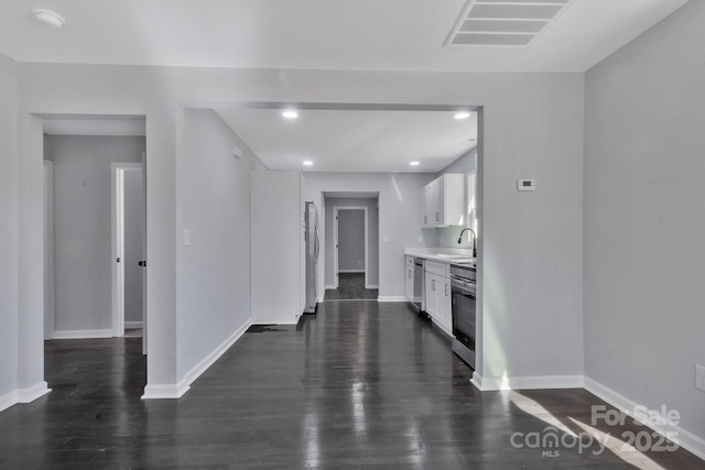 interior space with baseboards, visible vents, dark wood finished floors, and a sink