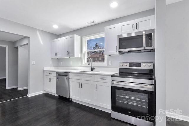 kitchen featuring a sink, white cabinetry, stainless steel appliances, and light countertops