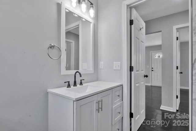 bathroom featuring vanity, baseboards, and wood finished floors