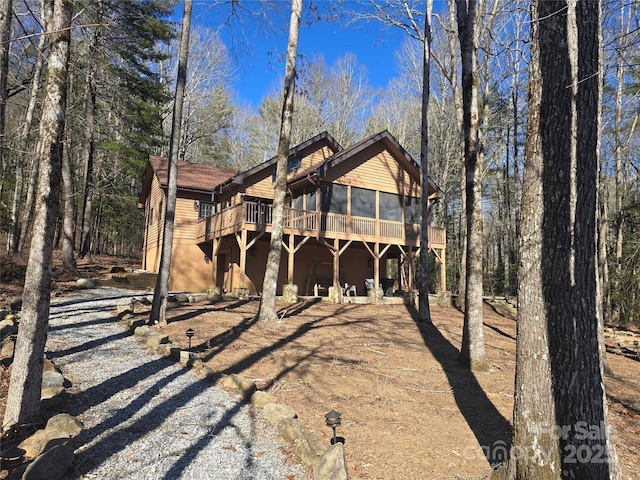 rear view of property featuring a sunroom and a deck