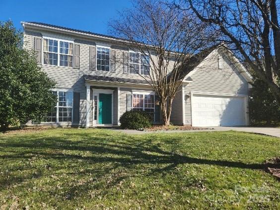 view of front of home featuring a front lawn, driveway, and an attached garage