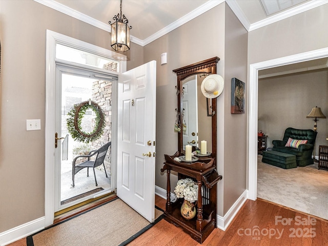 entrance foyer featuring baseboards, a chandelier, crown molding, and wood finished floors