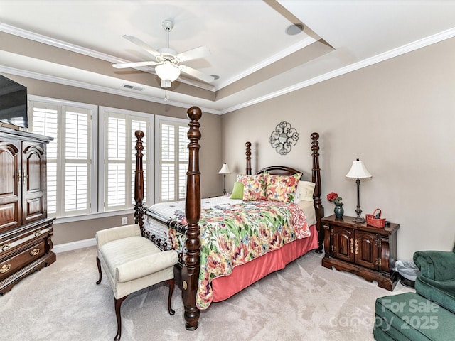 carpeted bedroom featuring a ceiling fan, a raised ceiling, visible vents, and crown molding