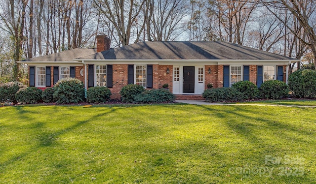 ranch-style house featuring brick siding, a chimney, and a front lawn