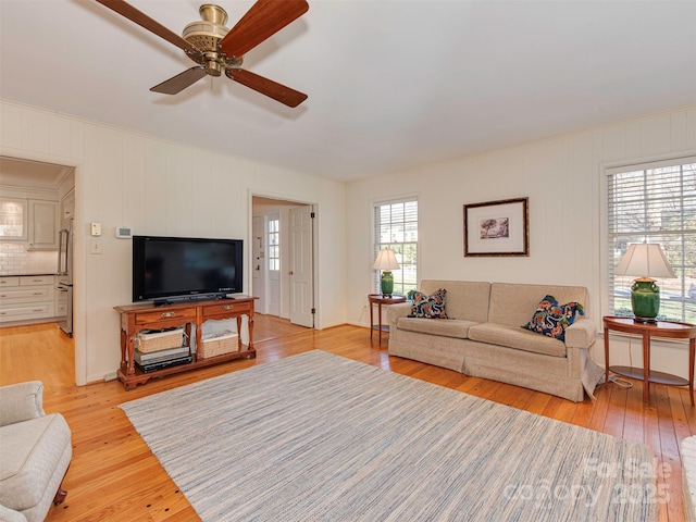 living area with ceiling fan and light wood-type flooring