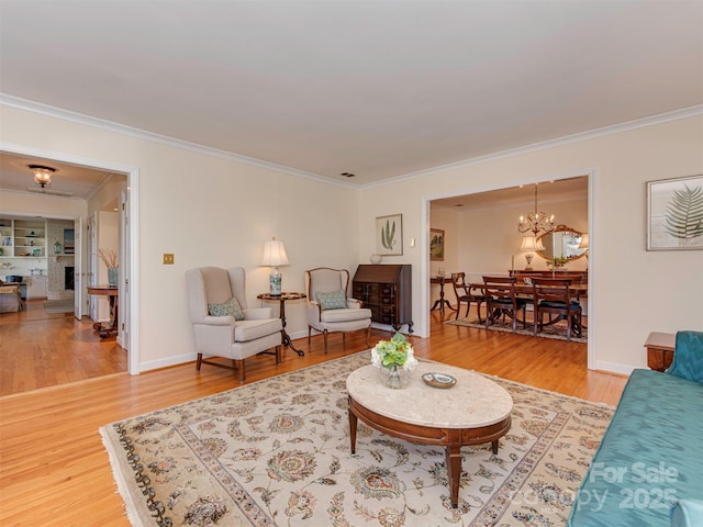 living room with ornamental molding, an inviting chandelier, wood finished floors, and baseboards