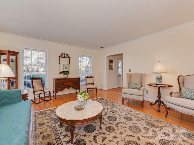 living area featuring light wood-style floors and crown molding