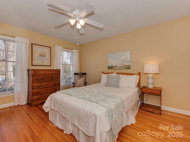 bedroom with light wood-style floors, ceiling fan, and baseboards