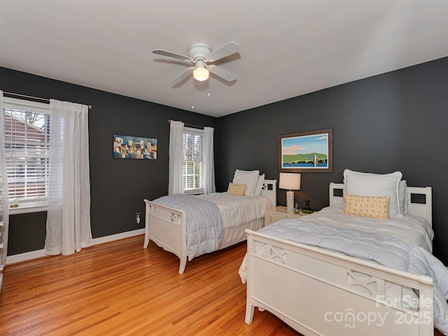 bedroom with light wood-style floors, baseboards, and a ceiling fan